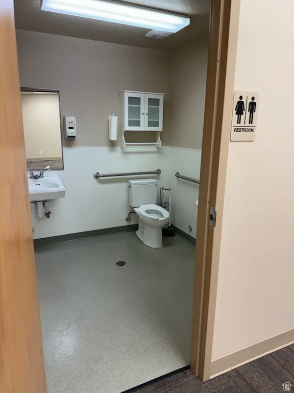 Half bathroom featuring toilet and baseboards