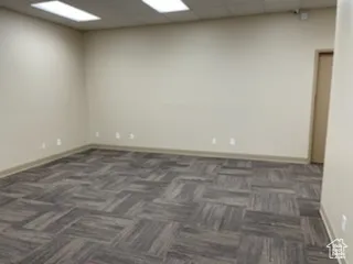 Empty room with carpet flooring and a paneled ceiling
