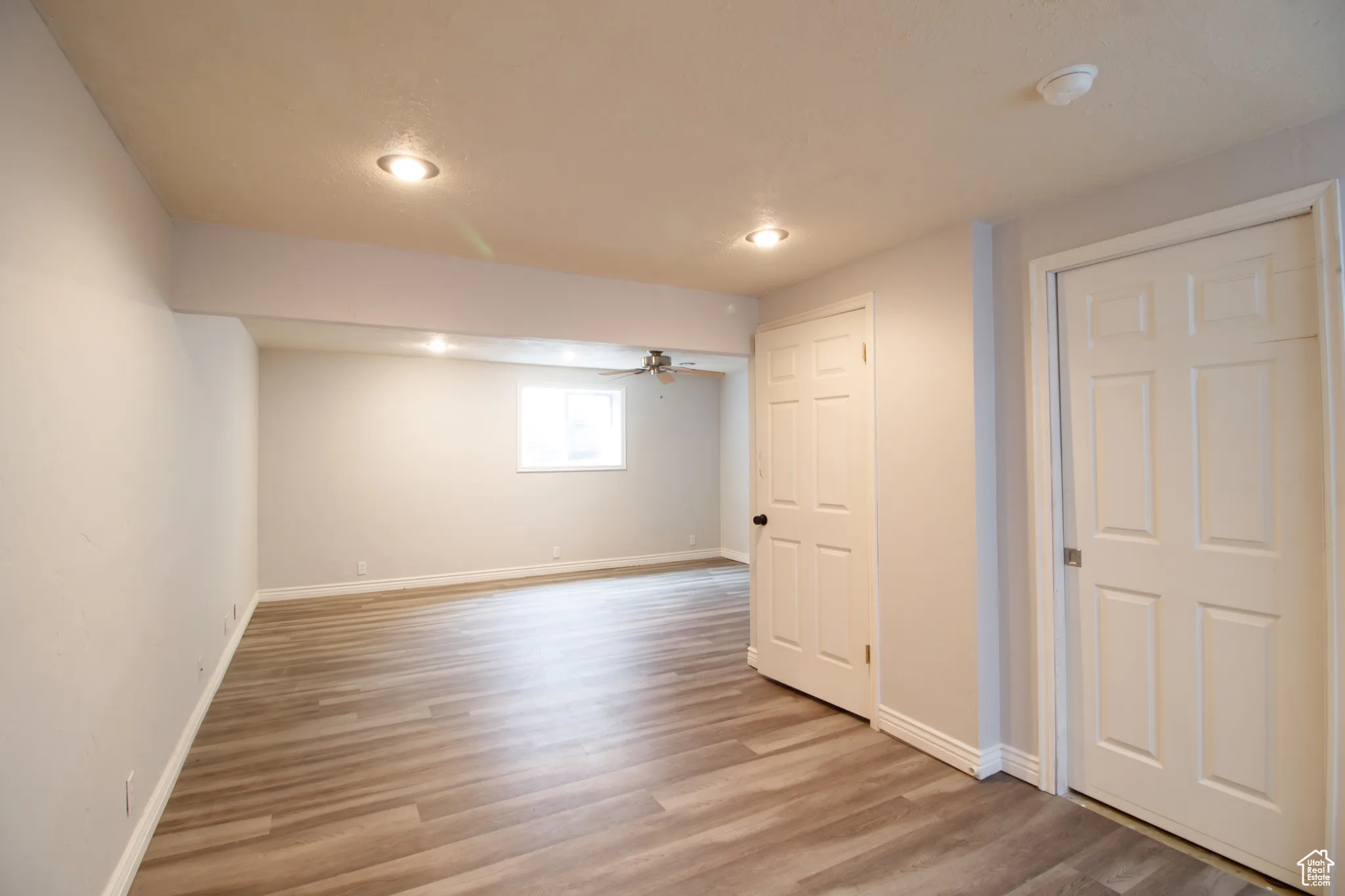 Below grade area with light wood finished floors, recessed lighting, and ceiling fan