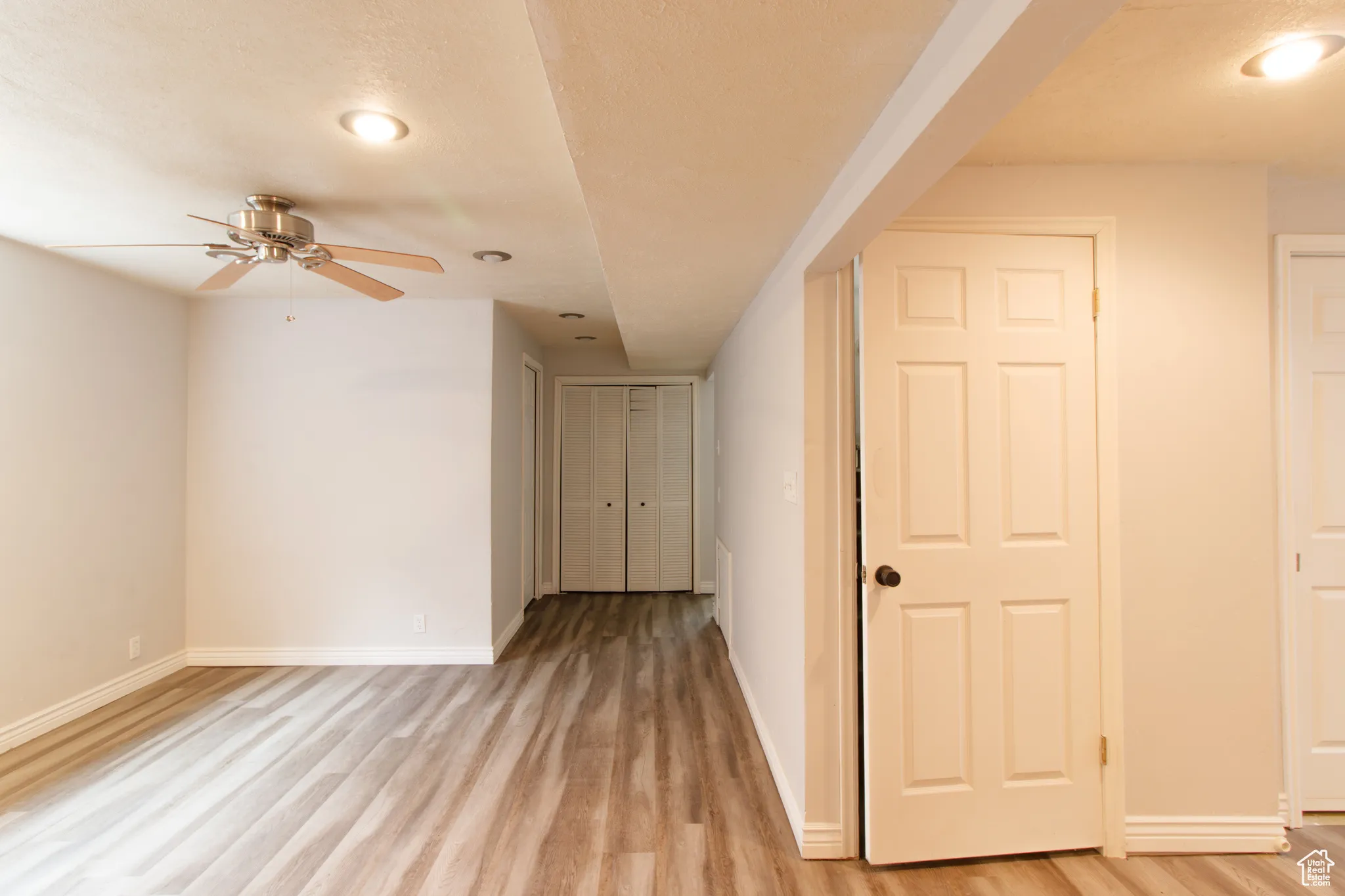 Empty room with a ceiling fan, light wood-style floors, and recessed lighting