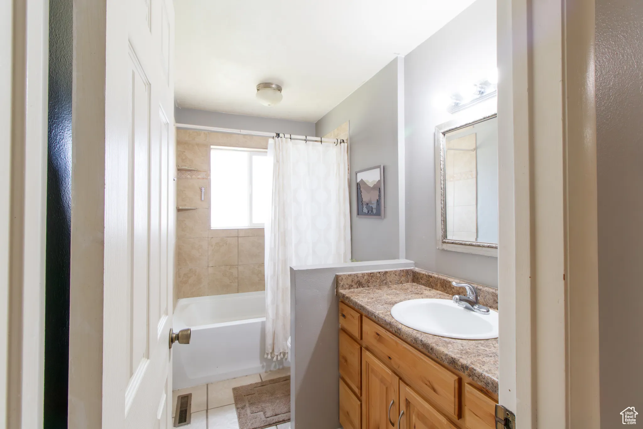 Bathroom with vanity, shower / bath combination with curtain, and tile patterned flooring