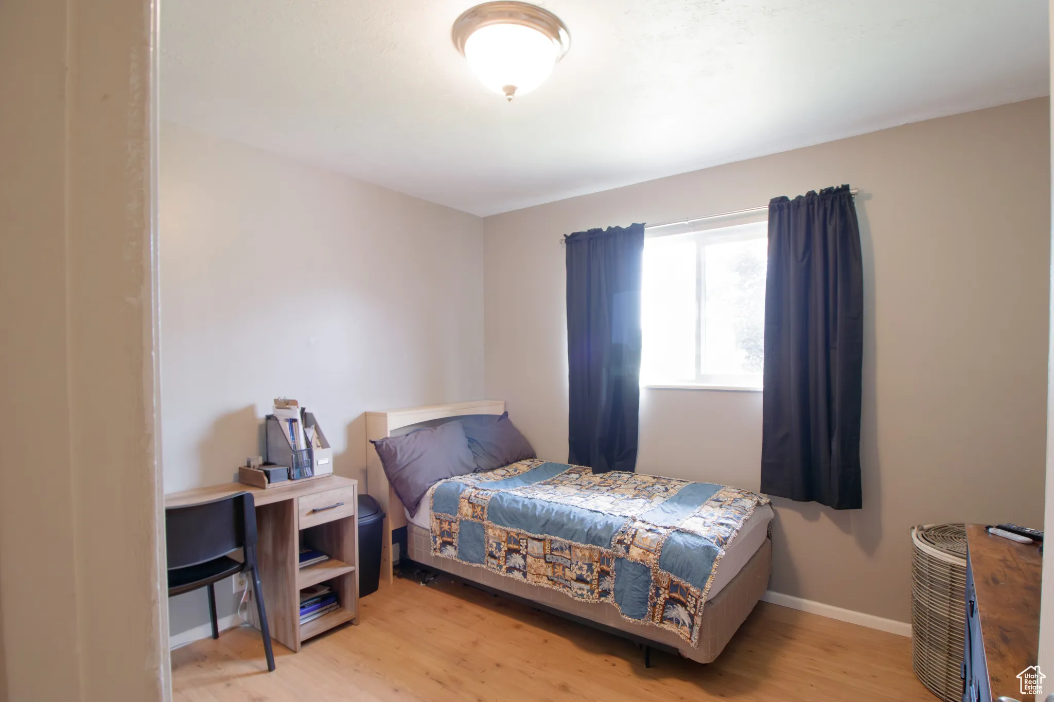 Bedroom with light wood-style flooring and baseboards