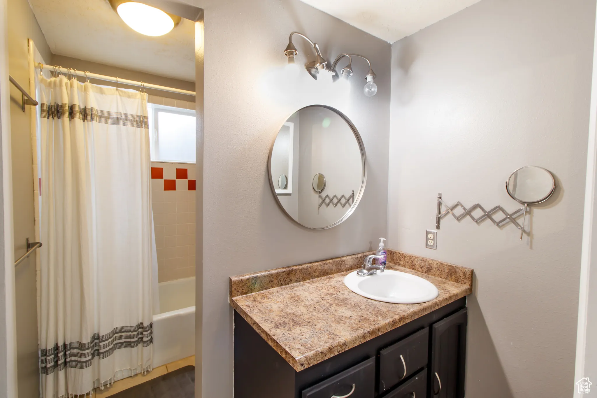 Bathroom with vanity and shower / tub combo with curtain
