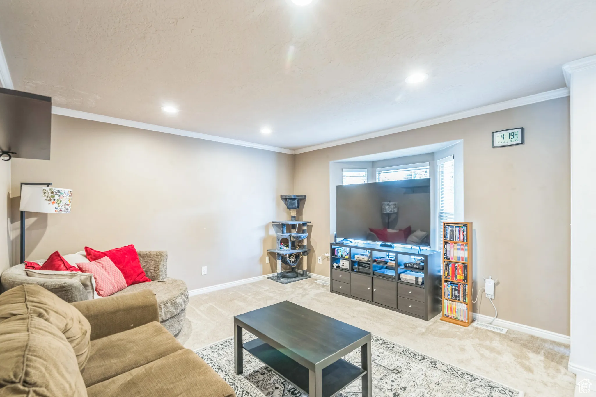 Living area with carpet flooring, crown molding, recessed lighting, and a textured ceiling