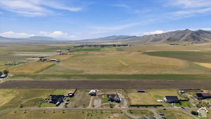 Aerial view of expansive acreage featuring open fields, mountain topography, and horizontal horizons