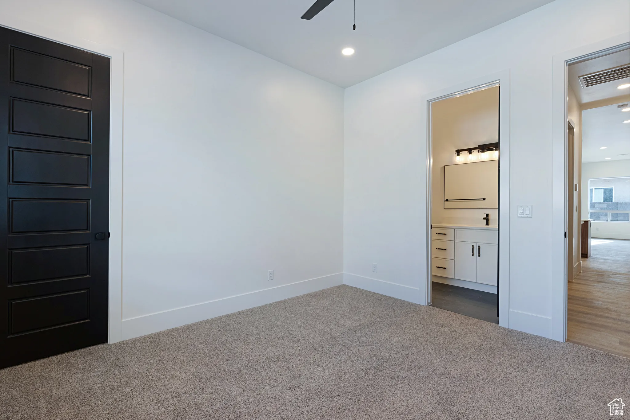 Unfurnished bedroom featuring carpet, connected bathroom, and recessed lighting