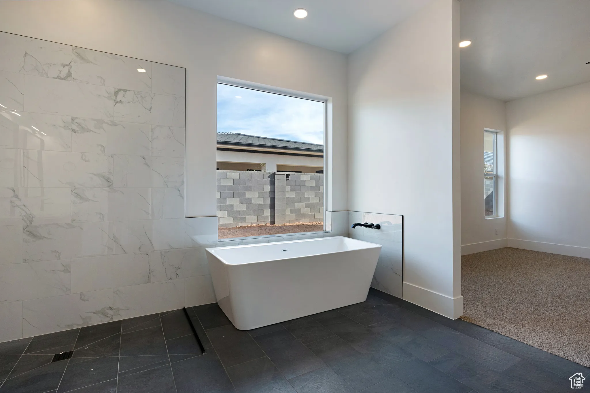 Full bathroom featuring plenty of natural light, a soaking tub, and recessed lighting