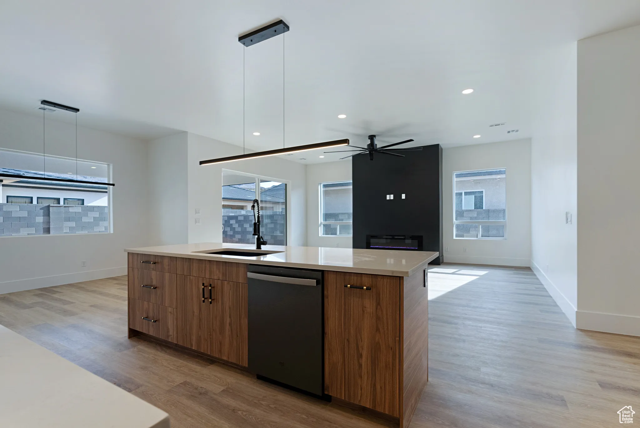 Kitchen featuring dishwasher, light wood-style floors, modern cabinets, an island with sink, and recessed lighting