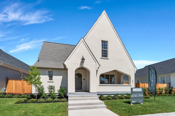 Stucco exterior with a steep gabled roofline and covered entry