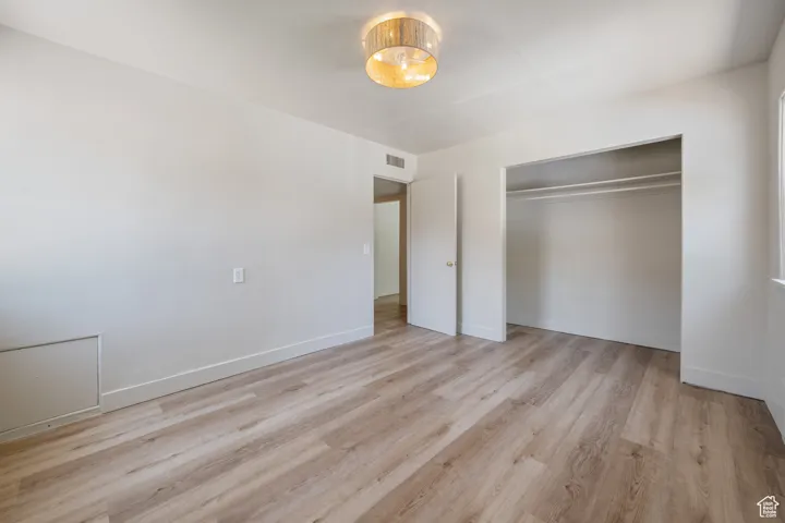 Unfurnished bedroom with light wood-type flooring and a closet
