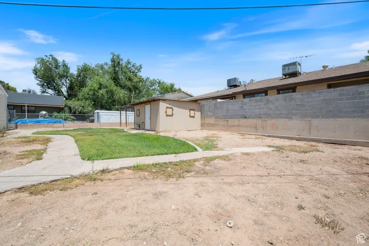View of home's exterior with a fenced backyard and a storage shed