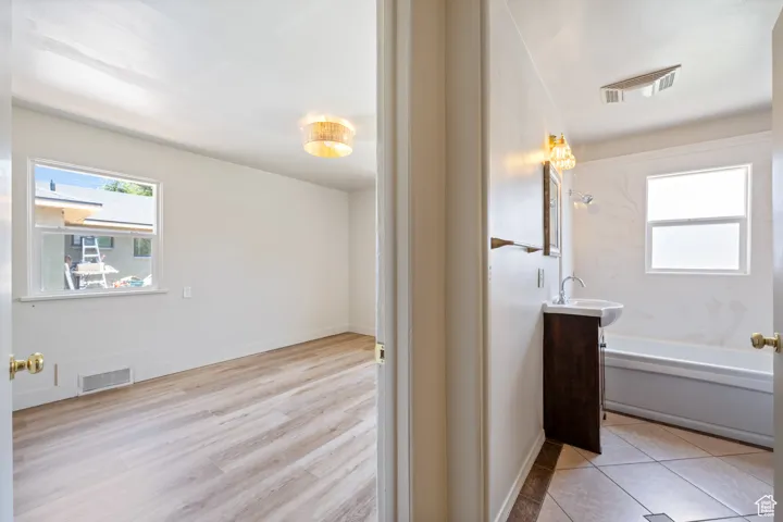 Full bath featuring vanity, tub / shower combination, and wood finished floors