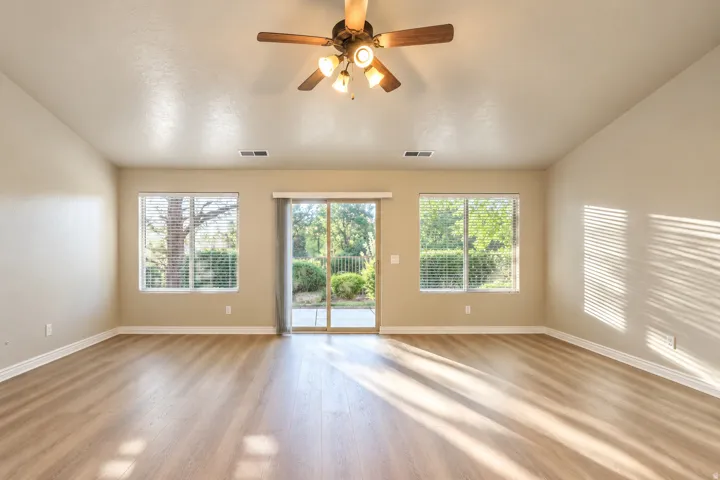 Wood-finish flooring with neutral wall tones and a vaulted ceiling