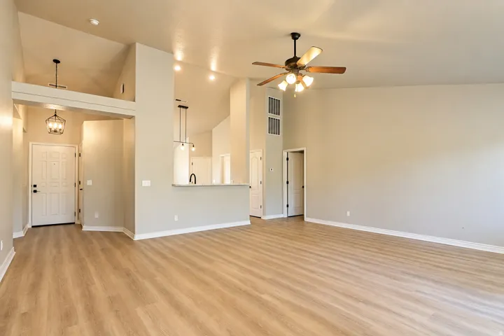 Vaulted ceilings, wood-finish flooring, ceiling fan, recessed lighting, and kitchen pass-through