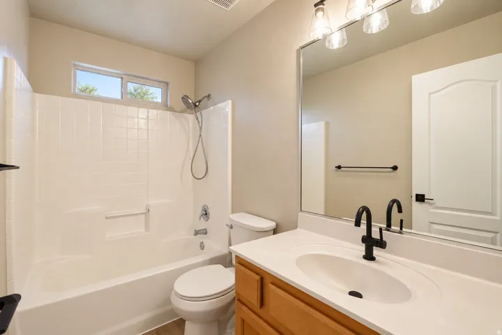 Full bathroom with a combined tub and shower featuring a window