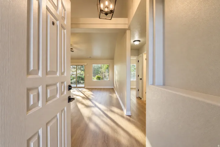 Wood-finish flooring throughout, vaulted ceilings, recessed lighting, and a sliding glass door