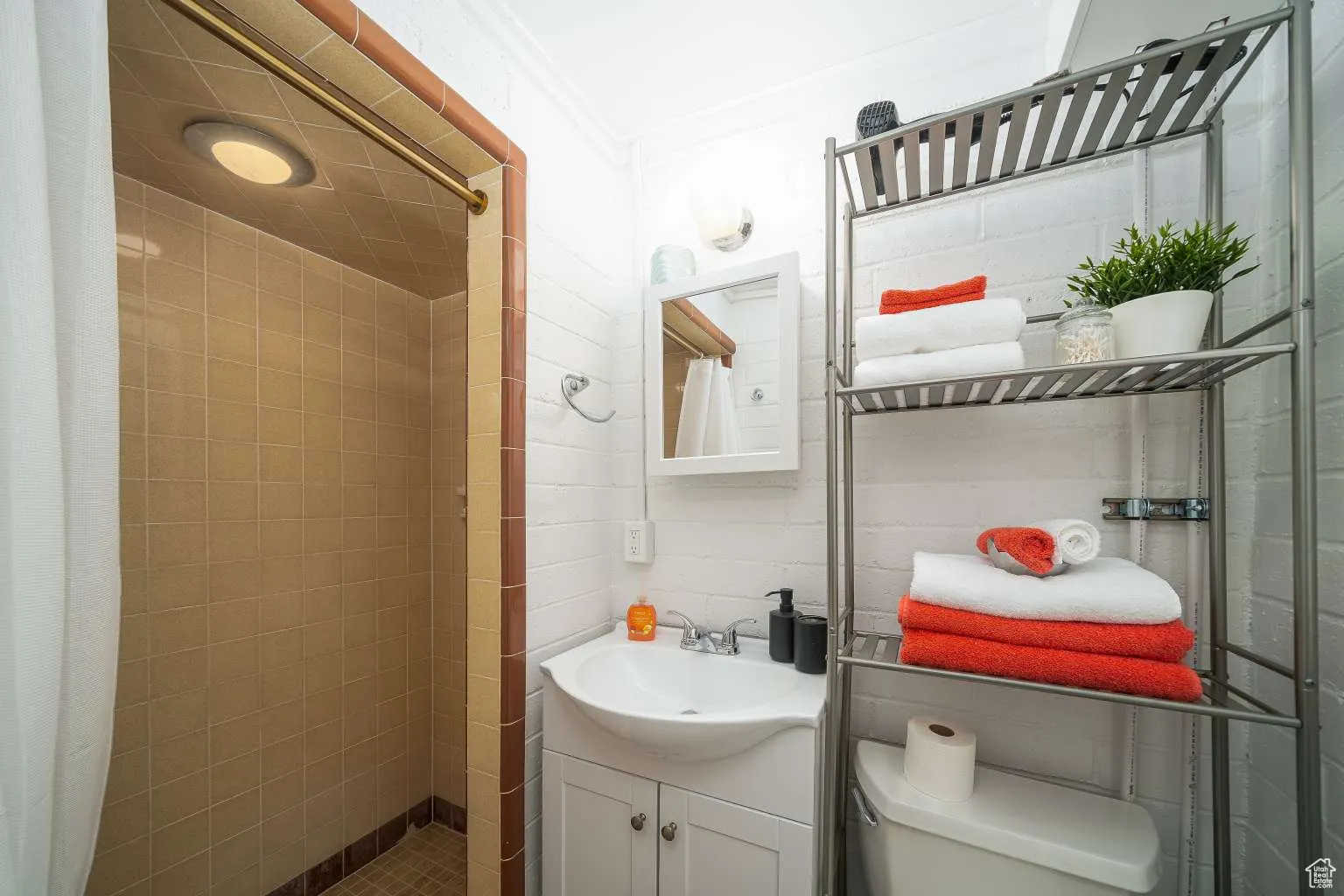 Bathroom with tiled shower and vanity