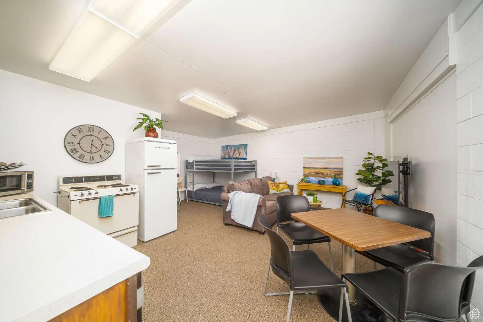 Dining room with concrete block wall and light colored carpet