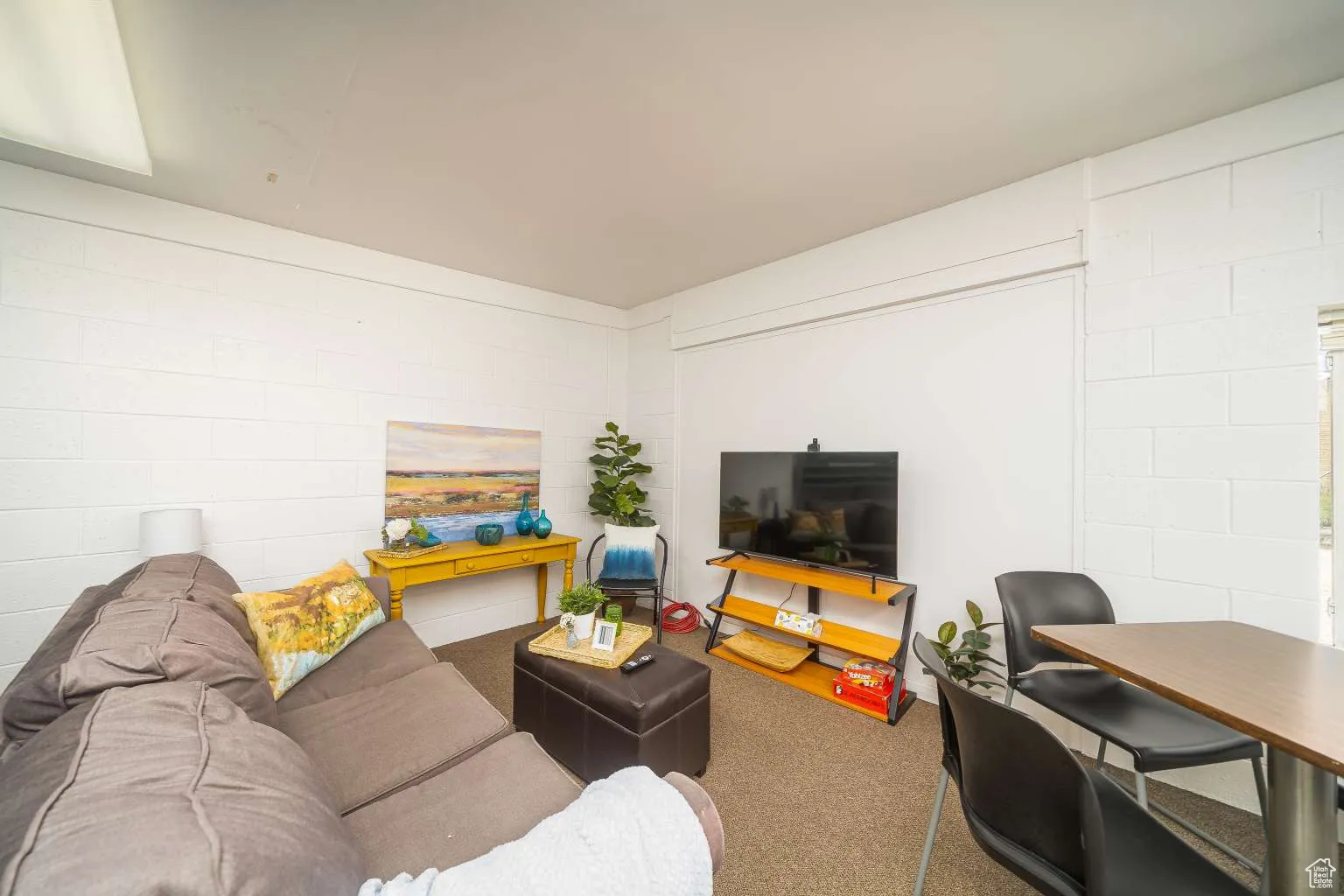 Living area with concrete block wall and carpet flooring