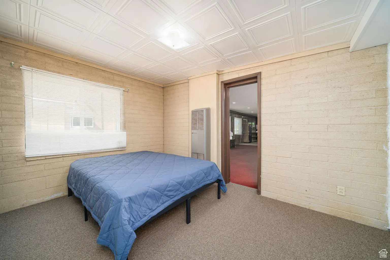 Bedroom featuring carpet flooring and a heating unit