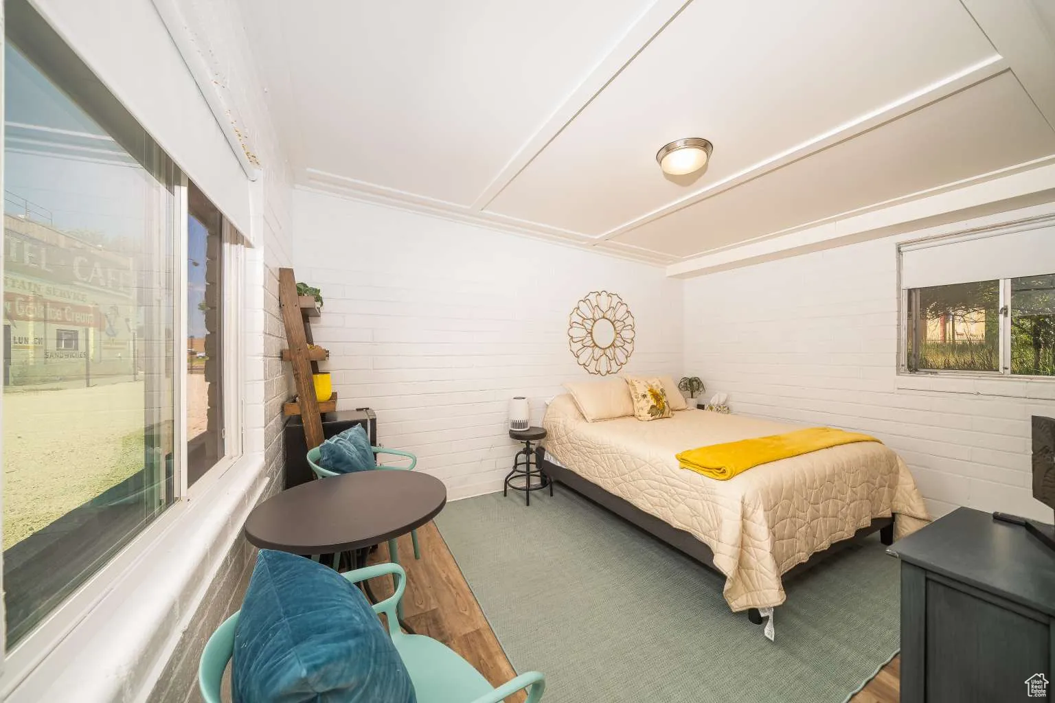 Bedroom featuring wood finished floors and brick wall