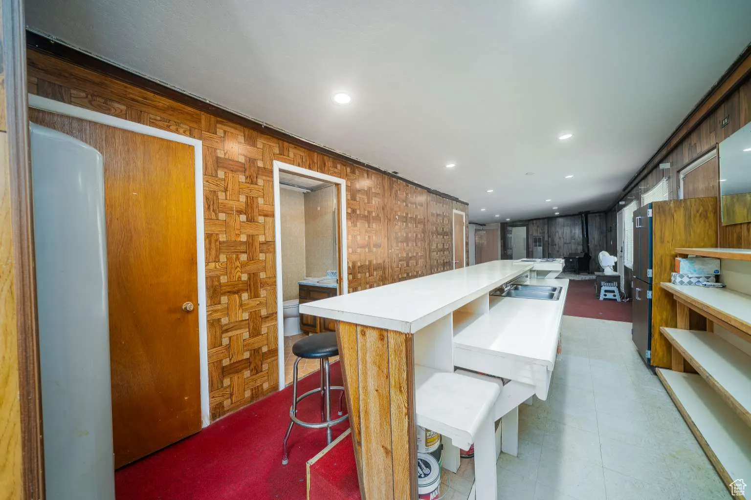 Kitchen with light countertops, recessed lighting, a large island, and a breakfast bar