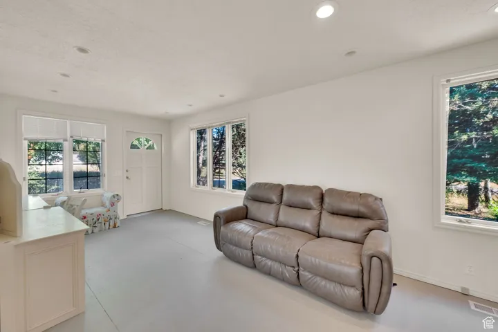 Living area featuring healthy amount of natural light, concrete floors, and recessed lighting
