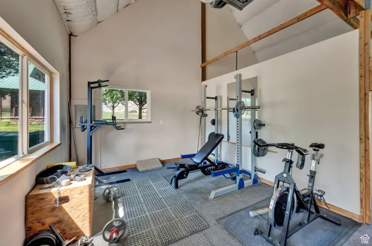 Workout area with carpet floors and high vaulted ceiling