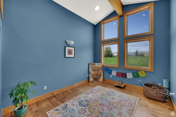 Living area featuring high vaulted ceiling, wood finished floors, beam ceiling, and recessed lighting