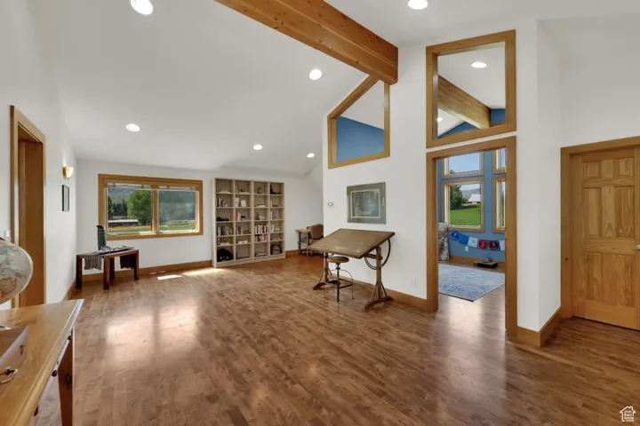 Entrance foyer with beam ceiling, recessed lighting, wood finished floors, and high vaulted ceiling