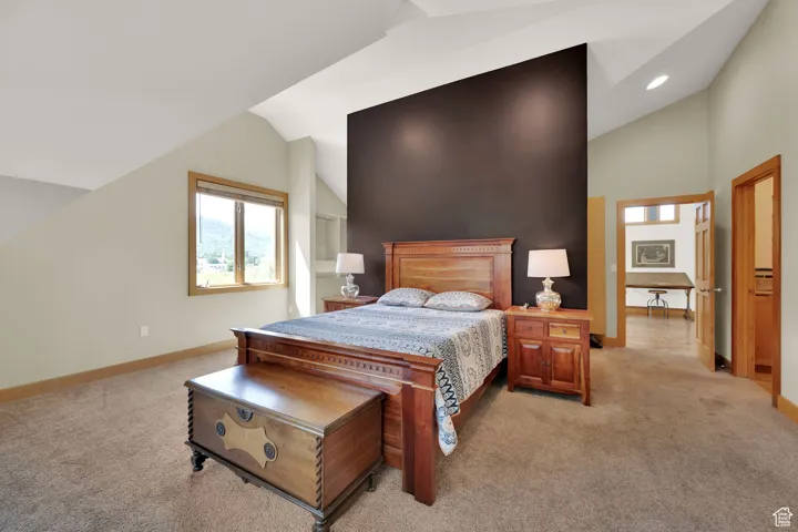 Bedroom featuring lofted ceiling, light carpet, and recessed lighting