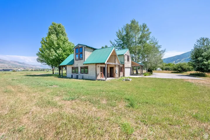 Chalet / cabin featuring driveway, a front yard, a metal roof, and a mountain view