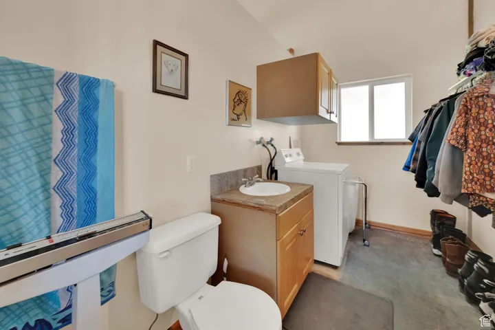 Bathroom with washing machine and clothes dryer and vanity