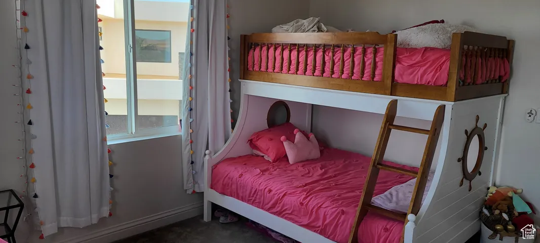 Bedroom with baseboards and dark carpet