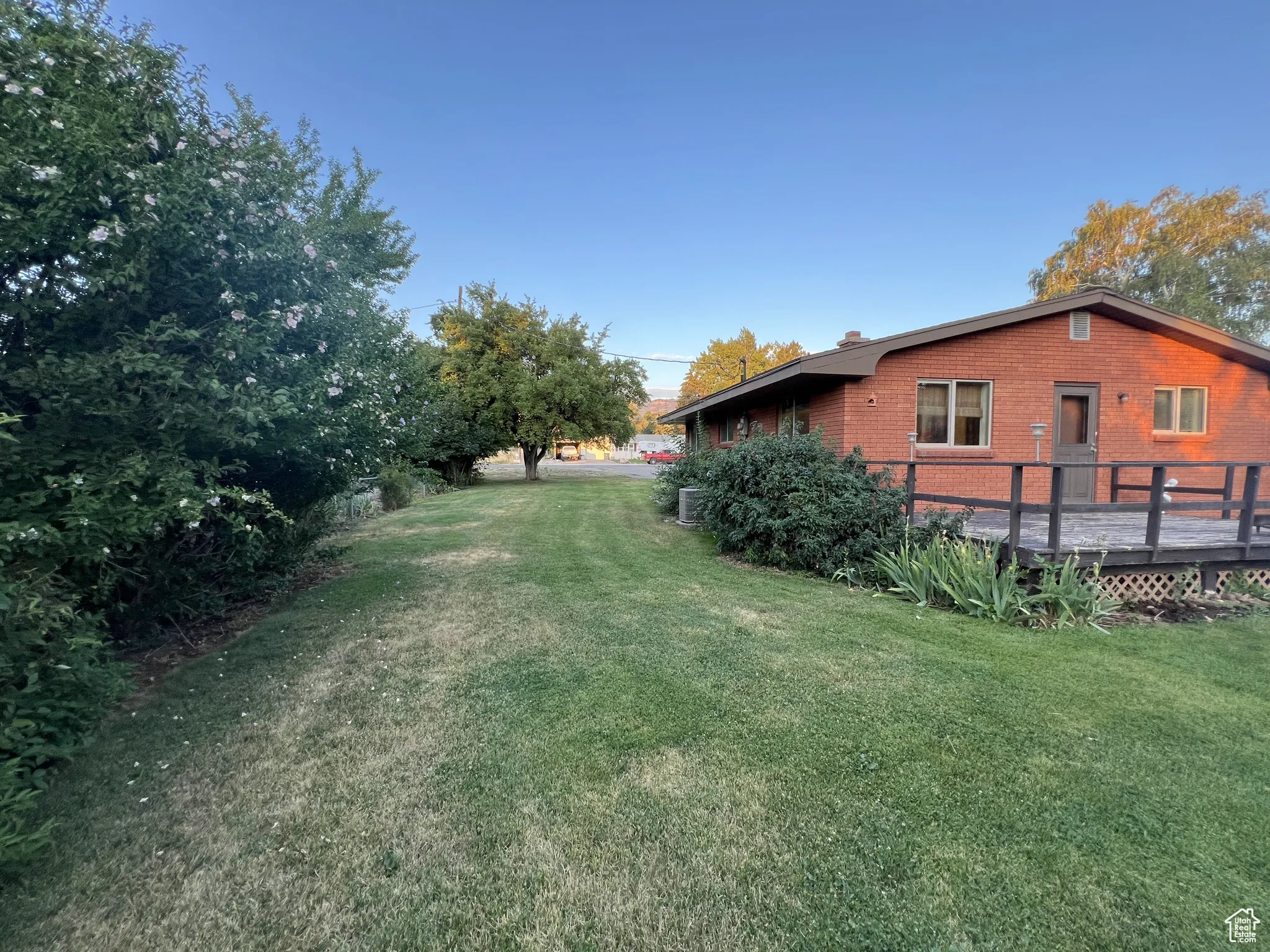 View of grassy yard featuring a deck