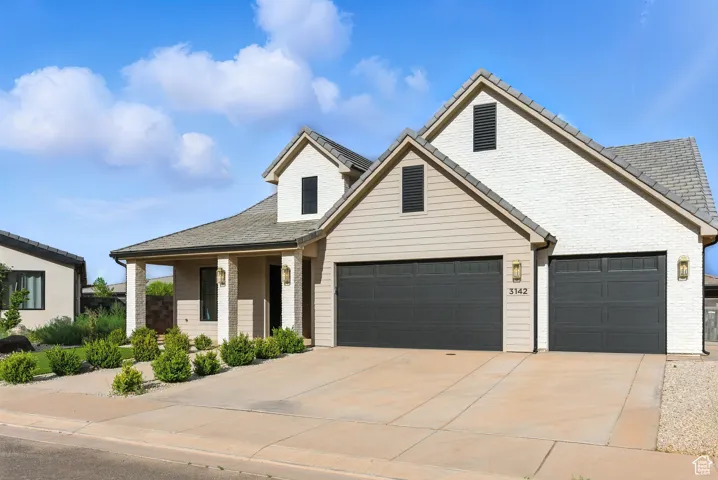 Traditional-style house featuring driveway and brick siding