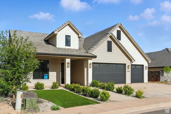 View of front of property with concrete driveway, brick siding, and a garage