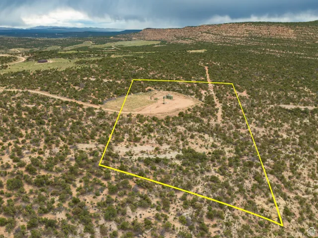 Aerial view of sparsely populated area featuring property parcel outlined and a mountainous background