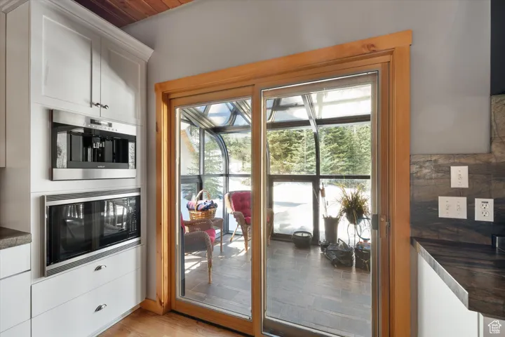 Doorway with light wood-style floors and baseboards