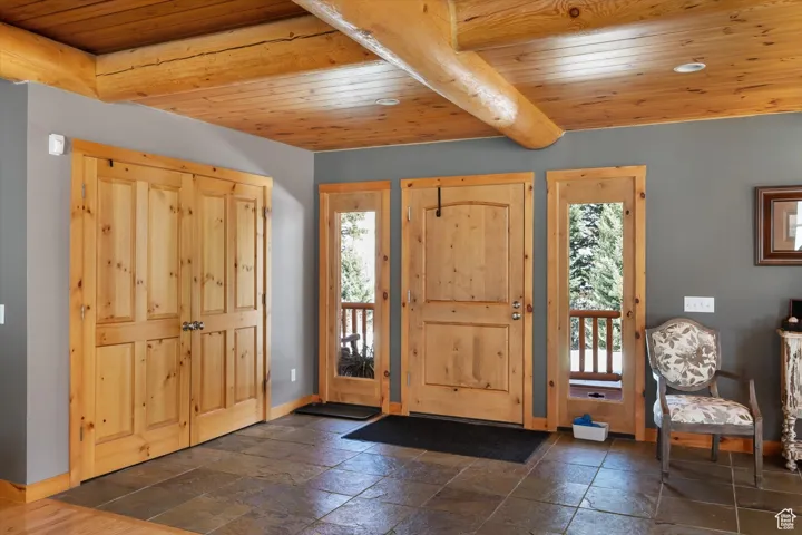 Foyer featuring wood ceiling and stone tile floors