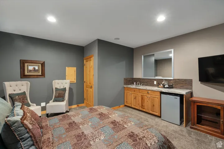 Kitchen featuring light carpet, fridge, decorative backsplash, and recessed lighting