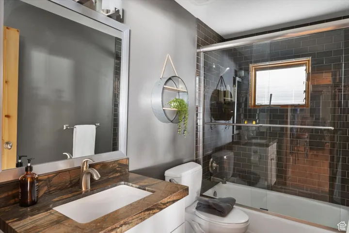 Bathroom featuring shower / bath combination with glass door and vanity