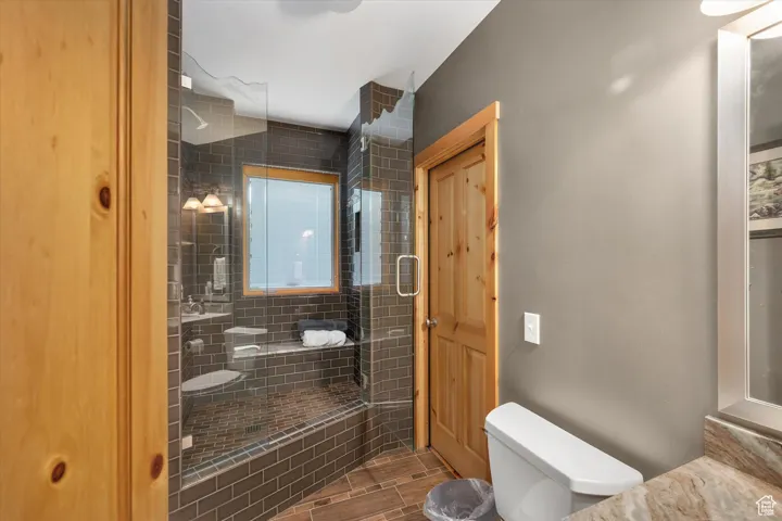 Full bath featuring toilet and a shower stall