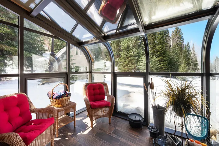 Sunroom with healthy amount of natural light, vaulted ceiling, and a baseboard heating unit