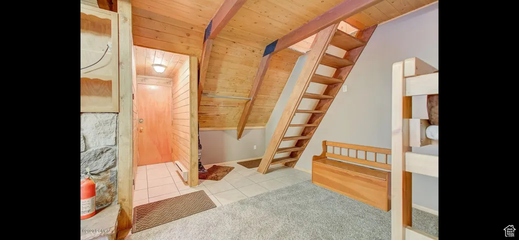 Bathroom with a wood ceiling with exposed beams and tile patterned floors