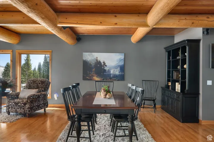 Dining room with light wood-style floors and a wood ceiling with exposed beams