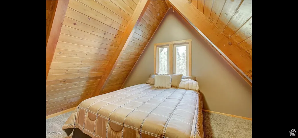 Bedroom featuring carpet flooring, wooden ceiling, and lofted ceiling