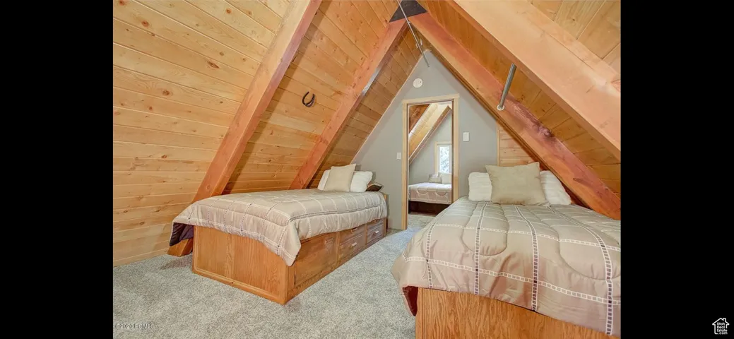 Carpeted bedroom featuring wooden ceiling