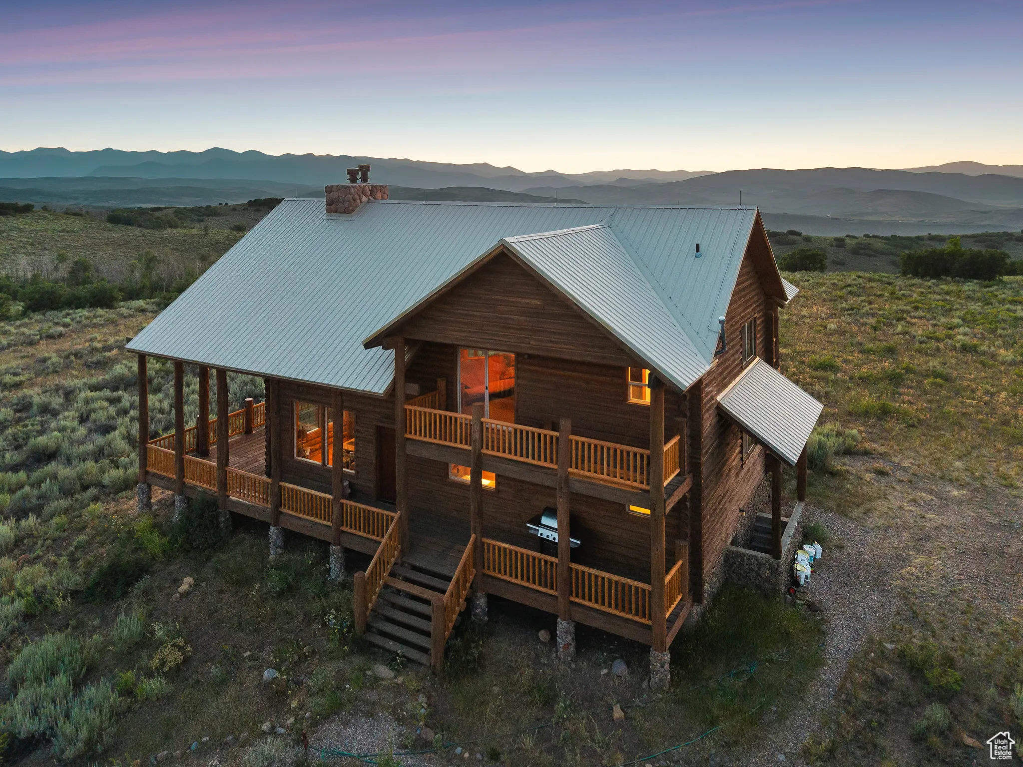 Rear view of house featuring a metal roof, a chimney, and a deck with mountain view
