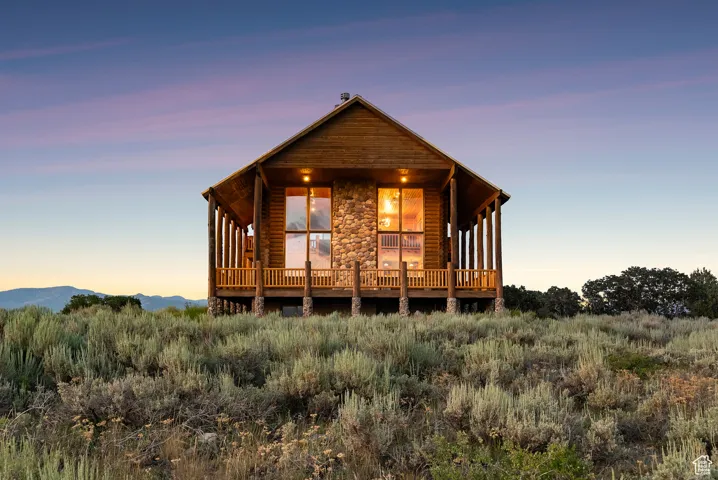 View of front of home featuring stone siding and log veneer siding